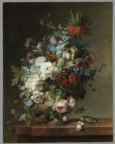Vase de fleurs sur une table de pierre, avec un nid et un verdier mâle