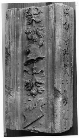 Fragment de pilastre : décor de masque feuillu tenant un bouquet de fruits, un casque et un cartouche