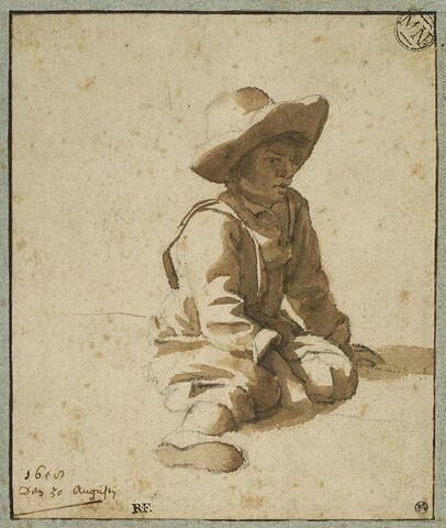 Jeune garçon assis à terre, coiffé d'un grand chapeau