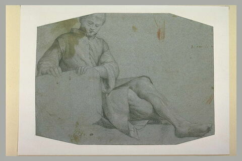 Jeune homme assis, les jambes étendues, les deux mains posées sur une pierre, image 1/1