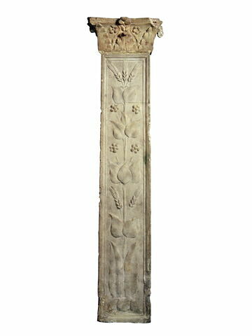 Pilastre orné de feuillages sur quatre facés et d'épis de blé avec chapiteau (d'origine différente)