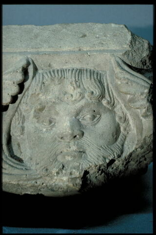 Fragment de tailloir décoré d'un masque barbu et de deux départs de rinceaux constitués de palmettes et de pommes de pin, image 2/4