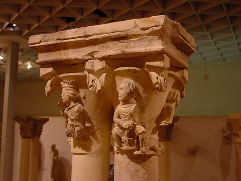 Fragment de chapiteau décoré de trois personnages dont l'un porte un vase et l'autre boite en présence d'un roi couronné, image 1/2
