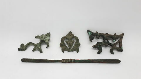 Quatre fragments d'élément d'applique ajouré à décor de volutes, en bronze