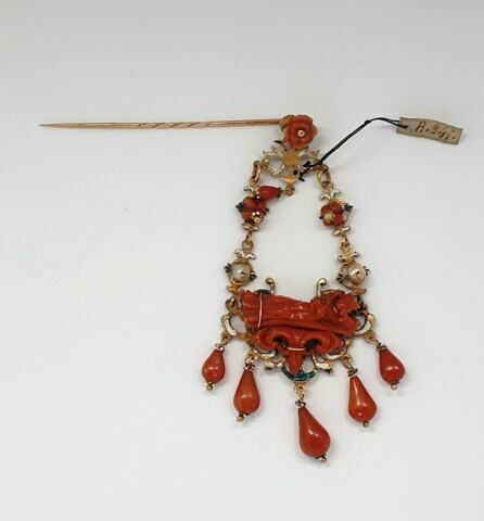 Pendentif en or émaillé et corail accroché à une épingle de cravate ornée d'une fleur en corail