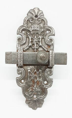 Verrou en métal repoussé de forme oblongue, décoré d'une coquille à la partie supérieure et à la partie inférieure