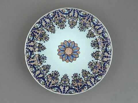 Grand plat circulaire en faïence, décor bleu et rouge de lambrequin au marli, et d'une rosace au centre., image 1/5