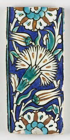 Carreau de bordure à l'oeillet et à la rosette sur fond bleu
