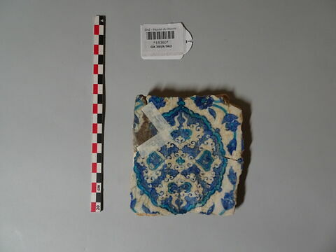 Fragment de carreau à mandorle meublée de nuages tchi en réserve et flanquée de rumis symétriques