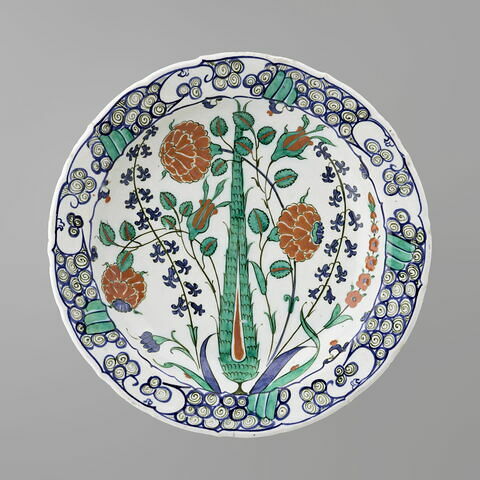 Plat au cyprès au centre d'un bouquet d'oeillets, de roses et de jacinthes
