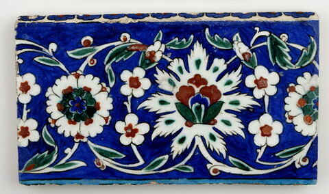 Carreau de bordure aux lotus alternant avec des fleurettes et des rosettes sur fond bleu, image 1/2