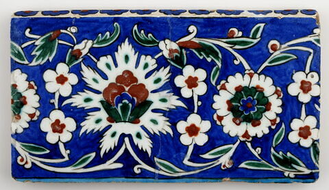 Carreau de bordure aux lotus alternant avec des fleurettes et des rosettes sur fond bleu, image 1/1