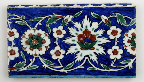 Carreau de bordure aux lotus alternant avec des fleurettes et des rosettes sur fond bleu, image 1/1