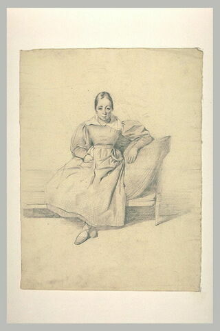 Femme assise, sur un canapé, de face, les pieds croisés