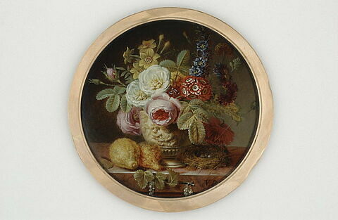 Vase orné de bas-relief et garni de fleurs