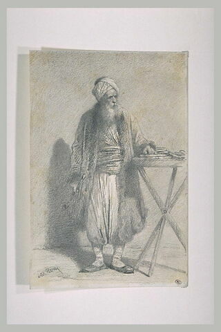 Vieil oriental à turban, barbu, debout, la main gauche appuyée sur une table, image 1/1