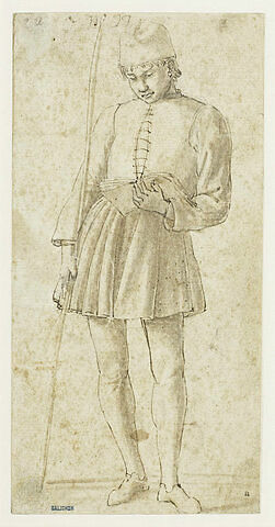 Jeune homme debout, tenant un bâton et lisant