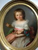 Portrait d'une petite fille jouant avec sa poupée et avec une petite perruche, image 1/2